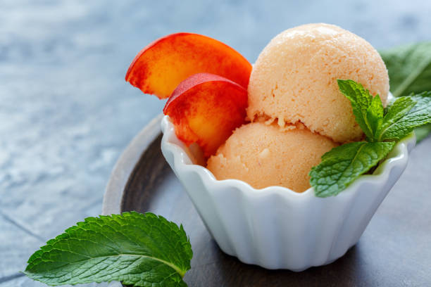 istock Peach ice cream in a white porcelain cup. 875795060