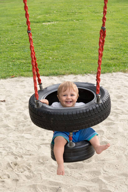 istock The boy is swinging on the tire 875800458