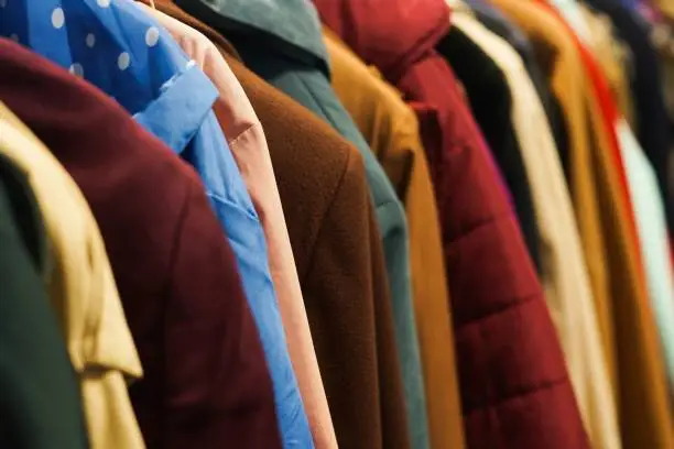 Rack with colourful coats. Charity second hand clothes.