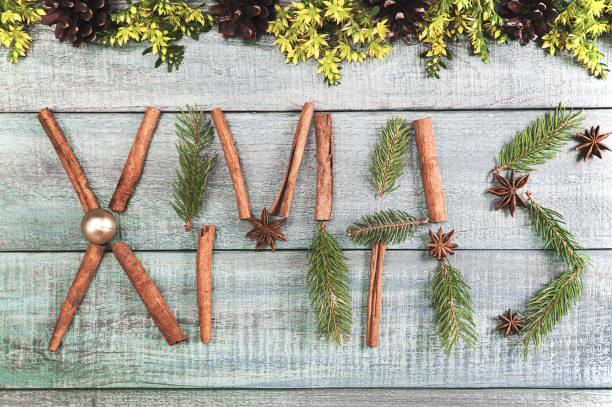 istock Christmas background or Xmas card  with decorations fir branches, pine cones, ornament, cinnamon, flower on the wooden green backtop. Winter holiday postcard. Vintage style. Top view and flat 875826328