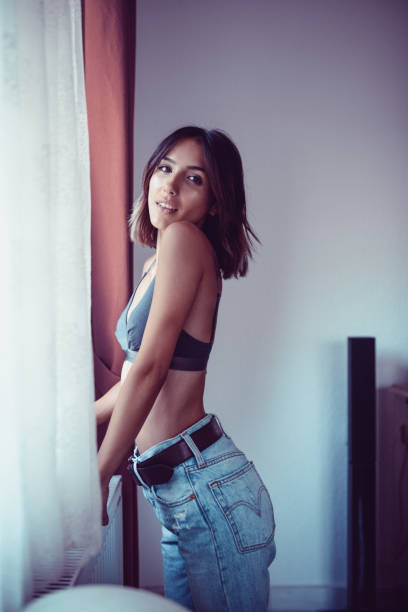 istock Young Sensual Female Posing by the Window at Home 875830338