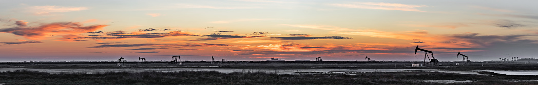 Panoramic image of an oil field at sunset