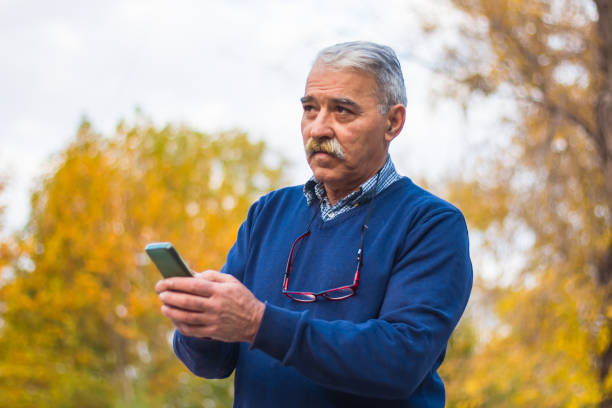 istock Senior man enjoying his smartphone outdoor. 875834300