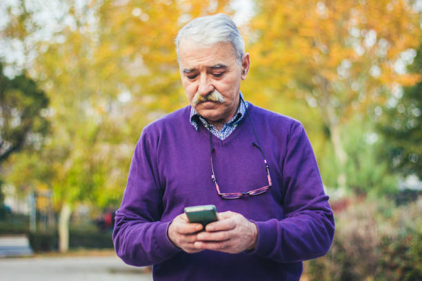 istock Senior man enjoying his smartphone outdoor. 875834432