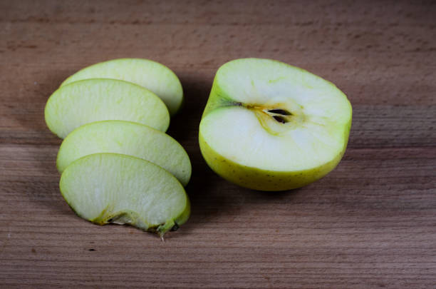istock Sliced green apple on wooden table 875841520