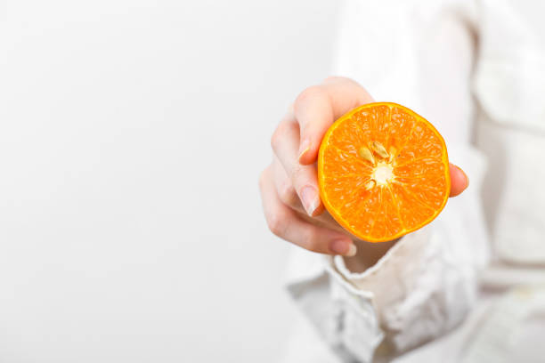 women Hand Holding a orange isolated on white