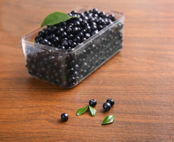 istock blueberries, currant with leaf in box on wooden background 875847756
