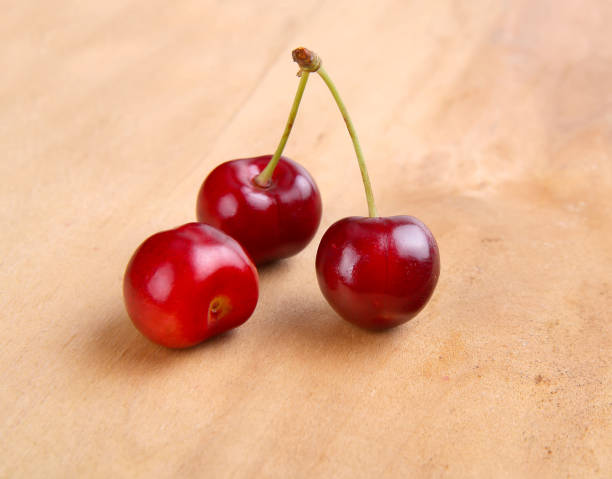 istock fresh red cherries on wooden background 875850218