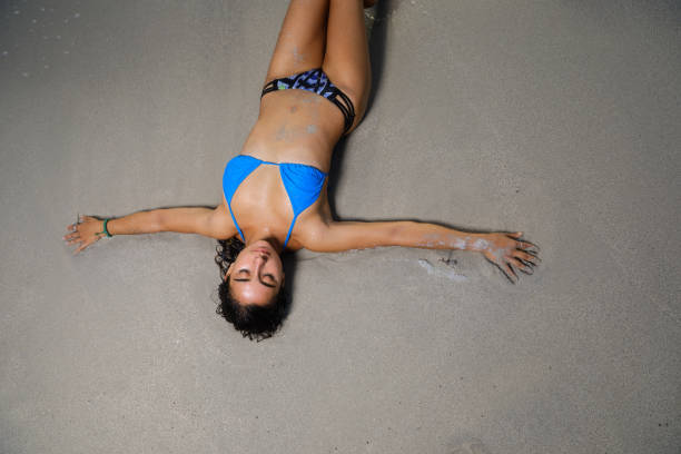 istock Overhead shot of a bikini model laying on the sand 875850470