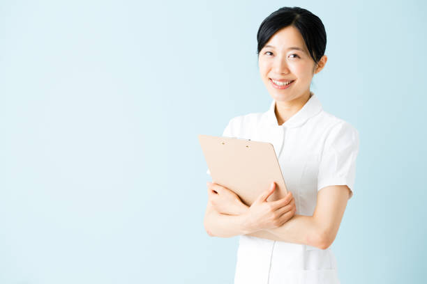 istock portrait of young asian nurse isolated on blue background 875879430