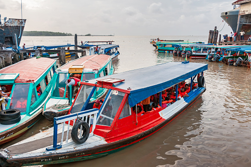 Commuters wait to depart while sitting in passenger boats docked at a dock in Georgetown, capital city of Guyana, South America.