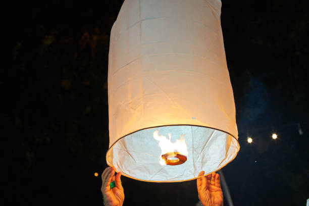 istock people launch a sky lantern on the annual festival (Yi Peng), on dark background 875907150