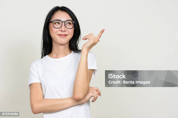 Young Beautiful Asian Woman Wearing White Shirt Against White Background Stock Photo - Download Image Now