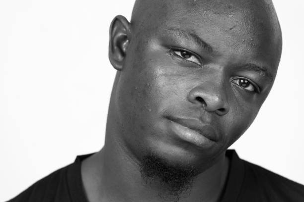 istock Young African man wearing black shirt against white background 875917368