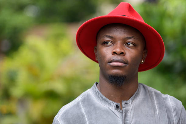 istock Young African man wearing red hat and boots outdoors 875919890
