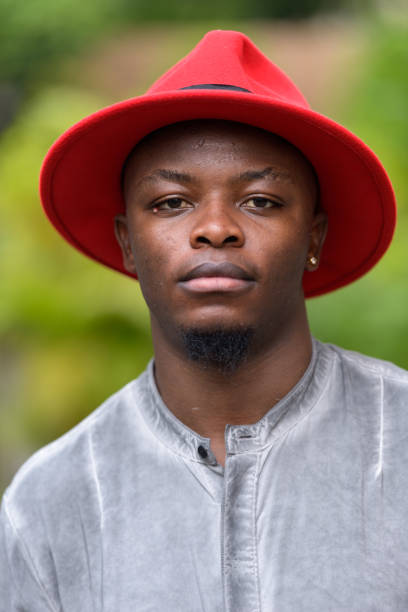 istock Young African man wearing red hat and boots outdoors 875919942