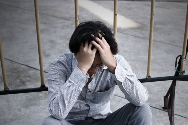istock Frustrated stressed young Asian business man covering forehead with hands and feeling disappointed at outside office. 875924432