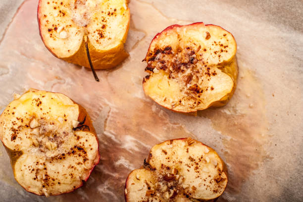 moitiés de pomme au four sur du papier cuisson - baked apple food meal dessert photos et images de collection