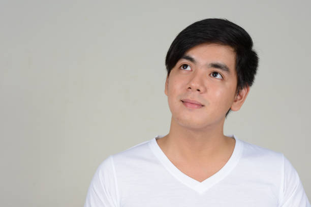 istock Young handsome Asian man wearing white shirt against white background 875925668
