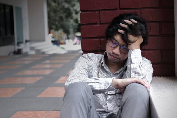 istock Frustrated stressed young Asian man touching head and feeling disappionted or exhausted. Unemployed businessman concept. 875925706