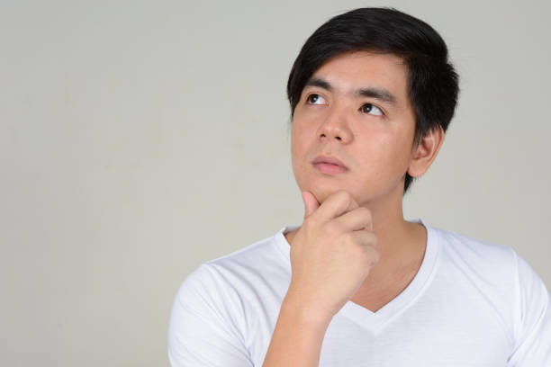 istock Young handsome Asian man wearing white shirt against white background 875925716