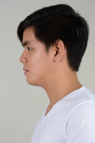 istock Young handsome Asian man wearing white shirt against white background 875928278