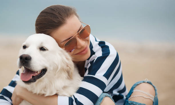 istock Young woman with a dog on a deserted beach 875928314