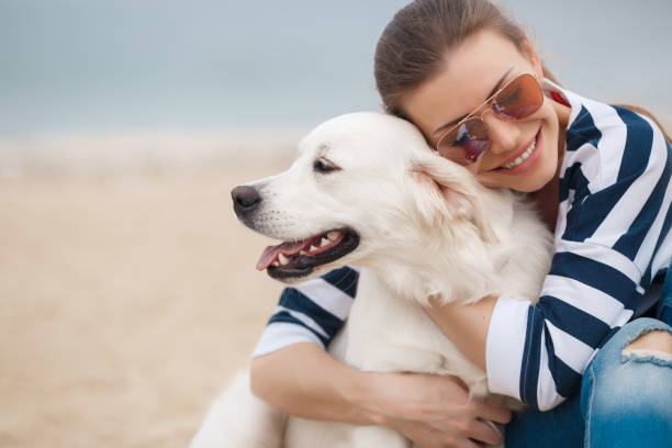 istock Young woman with a dog on a deserted beach 875928338