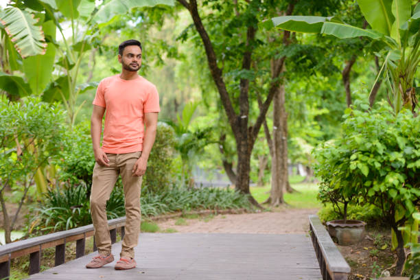 istock Young Indian man relaxing at the park 875935358