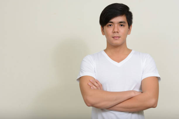istock Young handsome Asian man wearing white shirt against white background 875936286