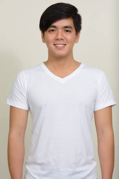 istock Young handsome Asian man wearing white shirt against white background 875936404