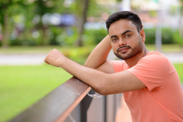 istock Young Indian man relaxing at the park 875937474