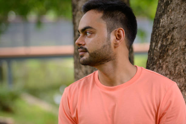 istock Young Indian man relaxing at the park 875939272