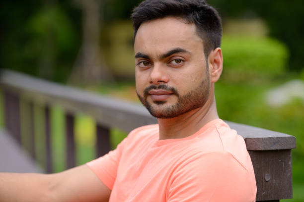 istock Young Indian man relaxing at the park 875941588