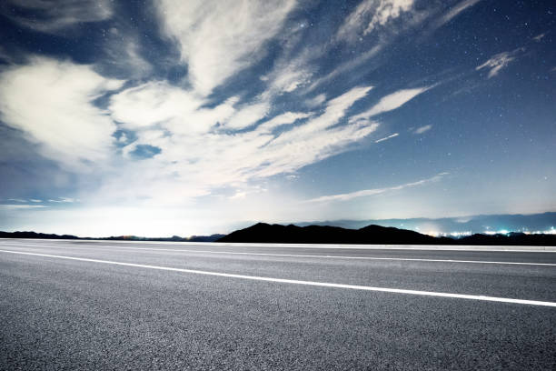 istock empty rural asphalt road with green hill in star sky 875949238