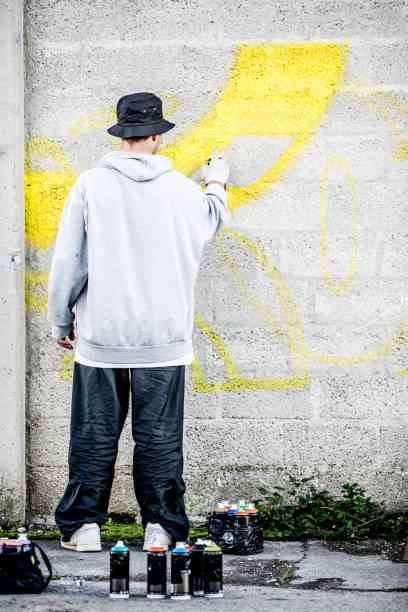 istock Young Graffiti Artist Coloring His Graffiti 875952348
