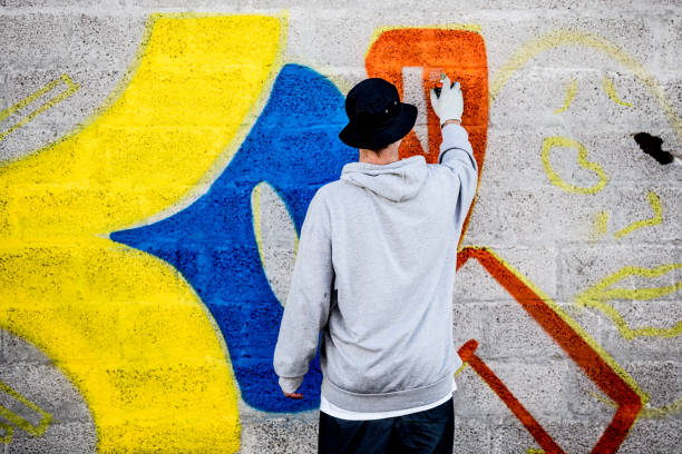 istock Young Graffiti Artist Coloring His Graffiti 875952362