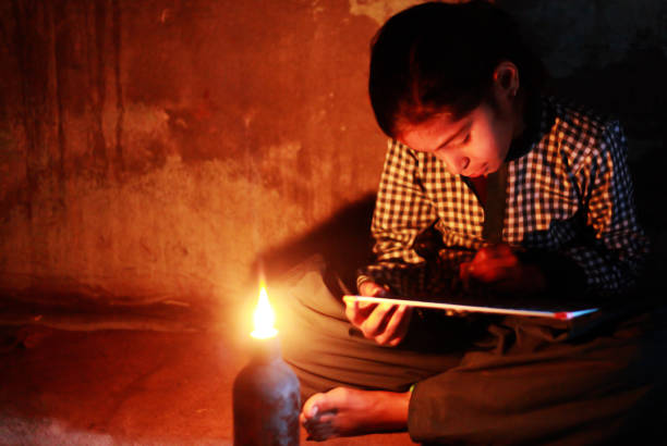poor little girl studying at home with lantern