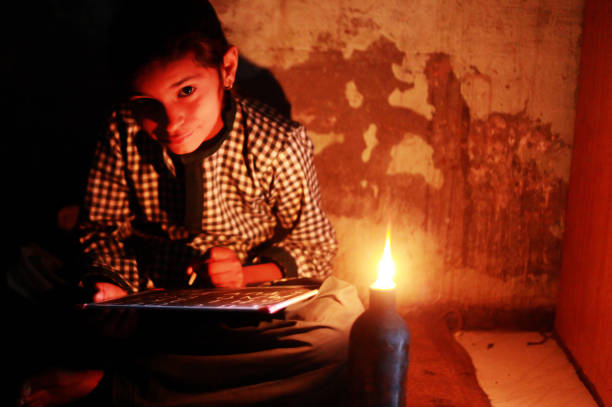 istock poor little girl studying at home with lantern 875961184