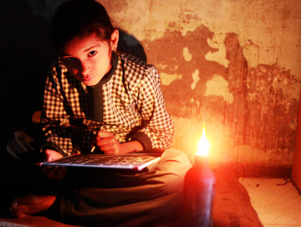 schlechte kleines mädchen studiert zu hause mit laterne - poverty india child little girls stock-fotos und bilder