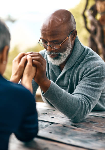 Couples who pray together, stay together Cropped shot of a senior couple praying outdoors religious occupation stock pictures, royalty-free photos & images