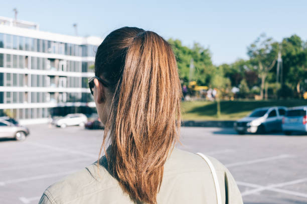 primer plano de una morena caminando por la ciudad en verano - ponytail brown hair tourist women fotografías e imágenes de stock