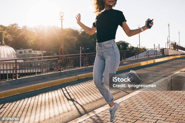 Happy Girl With Curly Brown Hair Jumping In The City Stock Photo - Download Image Now