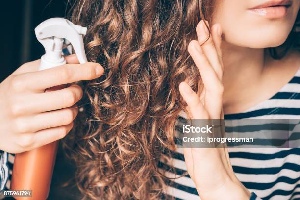 Frau Anwendung Spray Auf Lockigen Braunen Haaren Stockfoto und mehr Bilder von Haarpflege - Haarpflege, Gelockt, Haar