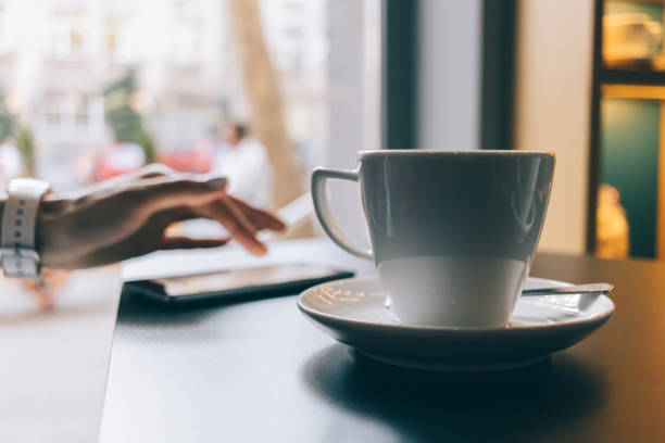 istock Woman in a cafe drinking coffee and using a mobile phone 875961802