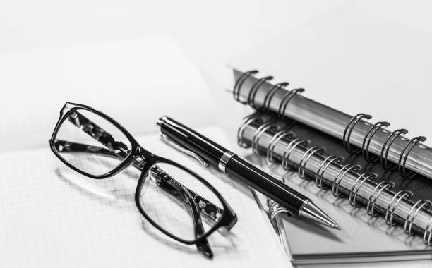 istock Glasses with pen and notebook on white background 875969160