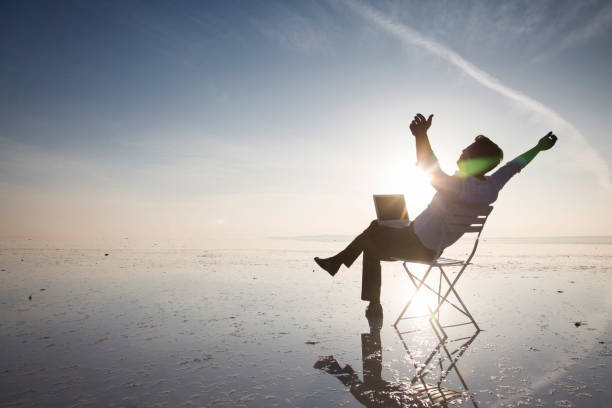 istock Business man with laptop working on the beach 875970936