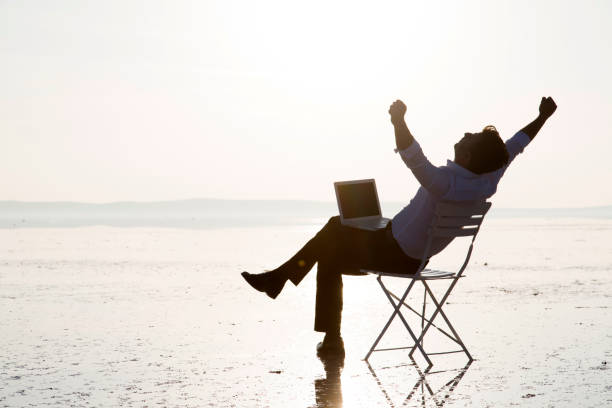 istock Business man with laptop working on the beach 875970962