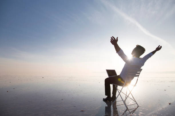 istock Business man with laptop working on the beach 875971014