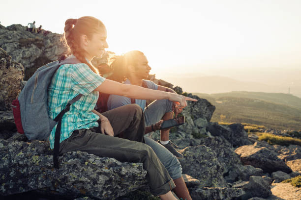 istock Friends sitting on the mountain peak relaxing and holding tablet 875971080